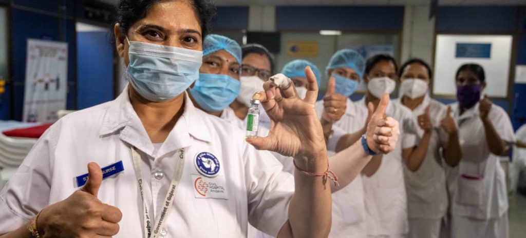 Trabajadores sanitarios posan con una dosis de la vacuna contra el COVID-19. Se necesita aumentar la producción y distribución de vacunas en todo el mundo.